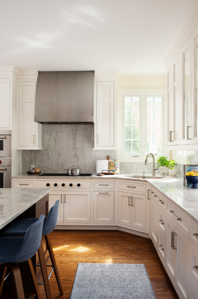 Example of a mid-sized transitional u-shaped medium tone wood floor and brown floor open concept kitchen design in DC Metro with an undermount sink, recessed-panel cabinets, dark wood cabinets, marble countertops, multicolored backsplash, marble backsplash, paneled appliances, an island and multicolored countertops