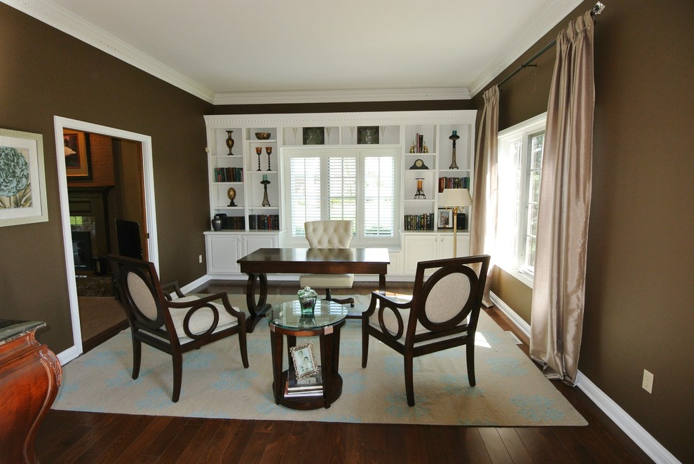 Photo of a large transitional study room in Indianapolis with brown walls, dark hardwood floors, no fireplace and a freestanding desk.