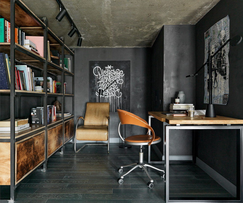 Aménagement d'un bureau industriel de taille moyenne avec une bibliothèque ou un coin lecture, un mur noir, un sol en bois brun, aucune cheminée, un bureau indépendant et un sol bleu.