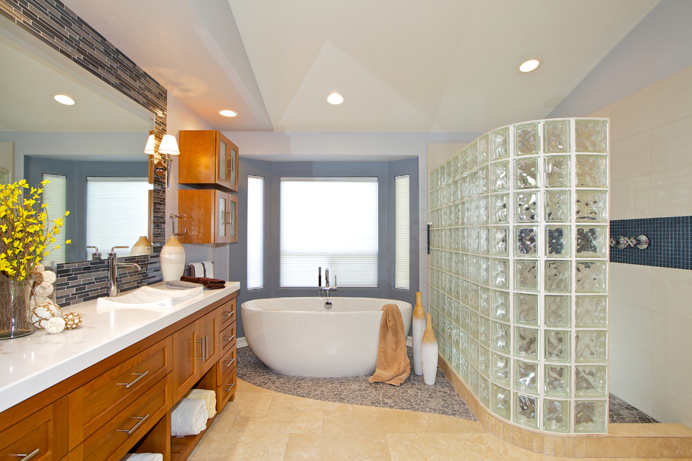 Design ideas for a contemporary bathroom in San Diego with mosaic tile, a drop-in sink, shaker cabinets, medium wood cabinets, solid surface benchtops, a freestanding tub, an alcove shower and multi-coloured tile.