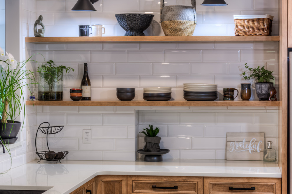 Kitchen - transitional l-shaped kitchen idea in Toronto with an undermount sink, shaker cabinets, light wood cabinets, white backsplash, stainless steel appliances, an island and white countertops