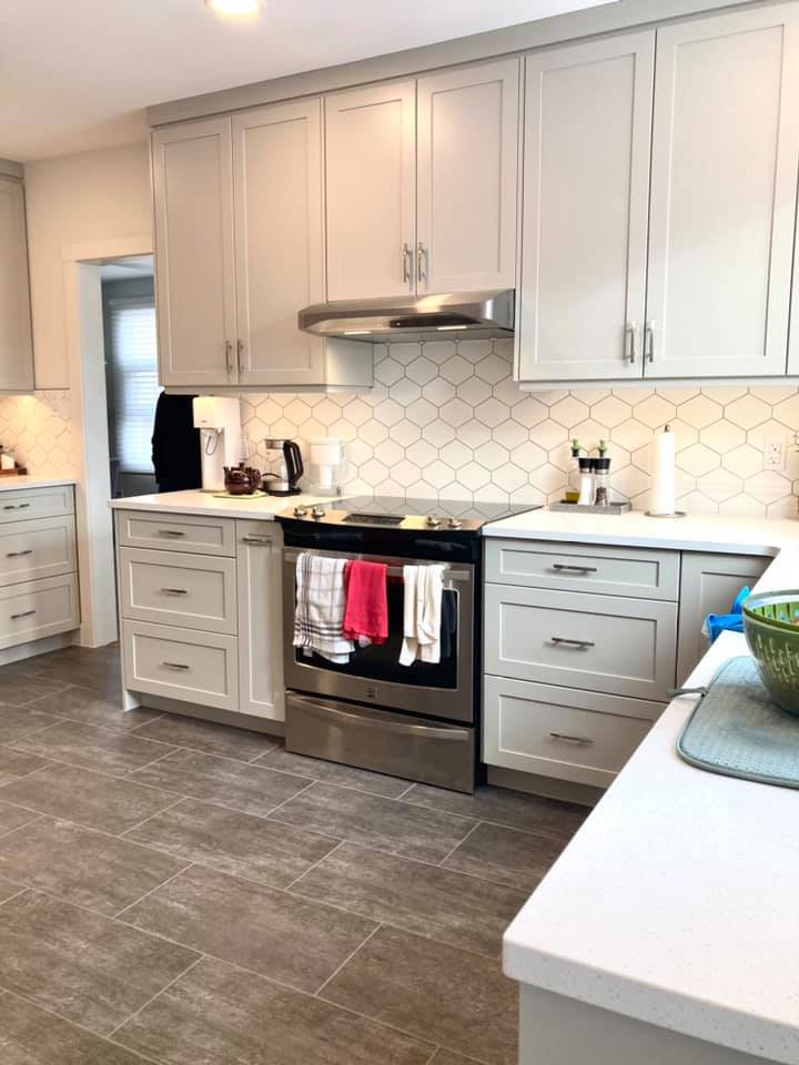 Enclosed kitchen - mid-sized transitional u-shaped vinyl floor and gray floor enclosed kitchen idea with an undermount sink, shaker cabinets, beige cabinets, quartz countertops, white backsplash, ceramic backsplash, stainless steel appliances and white countertops