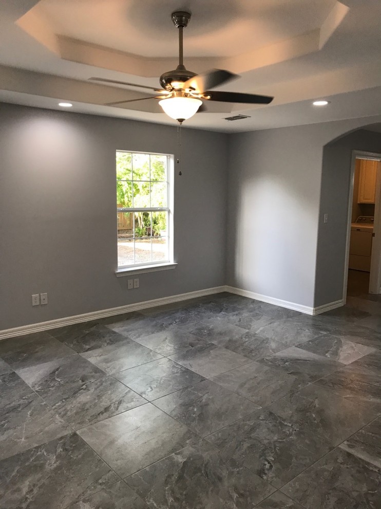 Photo of a mid-sized traditional master bedroom with grey walls, ceramic floors, no fireplace and grey floor.