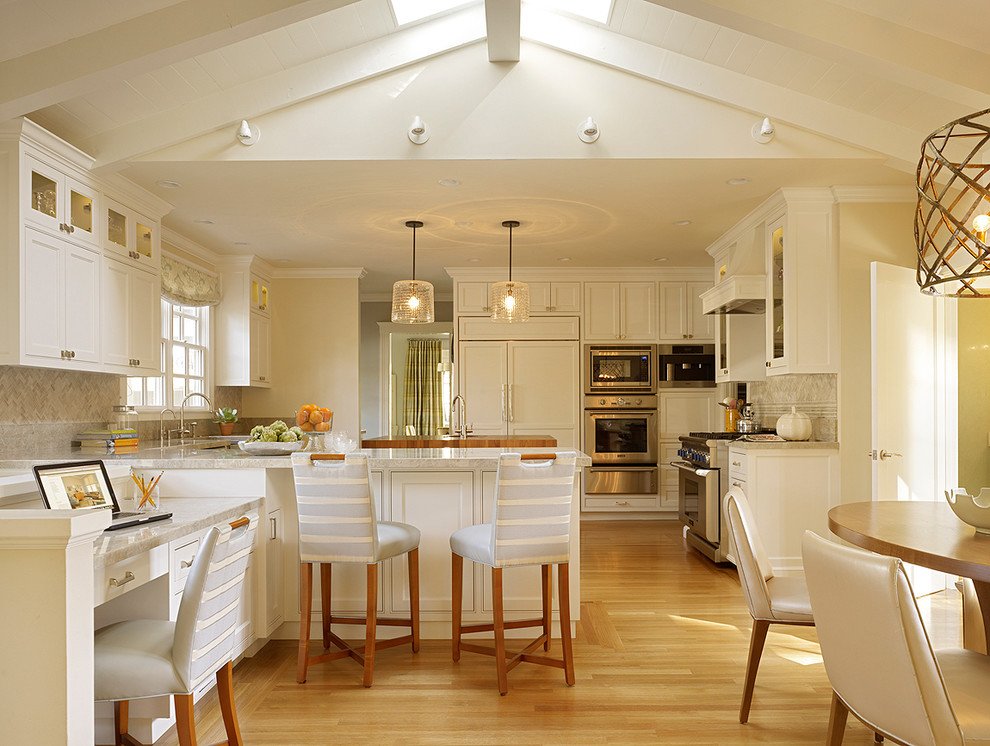 Inspiration for a transitional light wood floor eat-in kitchen remodel in San Francisco with shaker cabinets, white cabinets, beige backsplash, stainless steel appliances and a peninsula