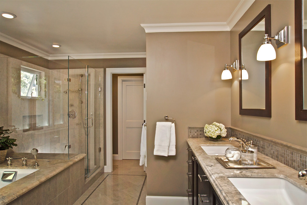This is an example of a large traditional master bathroom in San Francisco with recessed-panel cabinets, dark wood cabinets, an undermount tub, an alcove shower, beige tile, brown tile, gray tile, glass tile, brown walls, an undermount sink and granite benchtops.