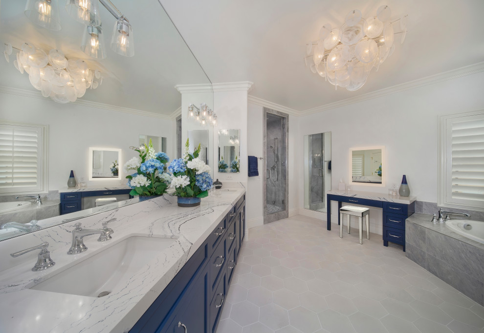 Пример оригинального дизайна: большая главная ванная комната в стиле неоклассика (современная классика) с фасадами в стиле шейкер, синими фасадами, накладной ванной, двойным душем, унитазом-моноблоком, белой плиткой, керамогранитной плиткой, белыми стенами, полом из керамогранита, врезной раковиной, столешницей из искусственного кварца, белым полом, душем с распашными дверями, синей столешницей, сиденьем для душа, тумбой под две раковины и встроенной тумбой