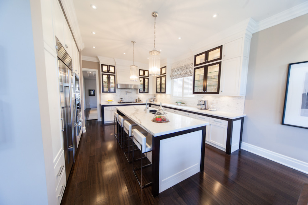 Example of a mid-sized transitional l-shaped dark wood floor and brown floor kitchen design in Toronto with an undermount sink, shaker cabinets, white cabinets, quartz countertops, multicolored backsplash, quartz backsplash, stainless steel appliances, an island and multicolored countertops