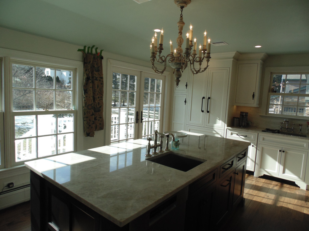 Inspiration for a large transitional u-shaped medium tone wood floor and brown floor eat-in kitchen remodel with an undermount sink, recessed-panel cabinets, white cabinets, quartzite countertops, beige backsplash, subway tile backsplash, stainless steel appliances, an island and beige countertops