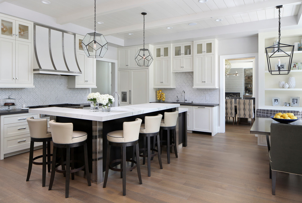 This is an example of a large transitional eat-in kitchen in San Francisco with white cabinets, multi-coloured splashback, ceramic splashback, with island, shaker cabinets, panelled appliances and light hardwood floors.