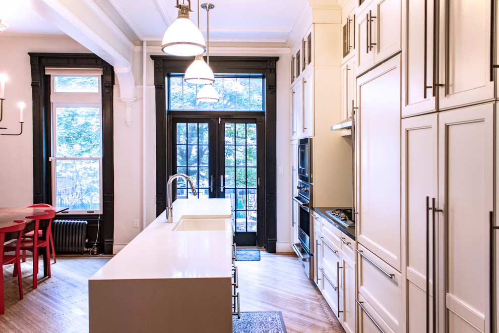 Eat-in kitchen - mid-sized transitional single-wall medium tone wood floor and brown floor eat-in kitchen idea with a farmhouse sink, shaker cabinets, white cabinets, quartz countertops, blue backsplash, porcelain backsplash, stainless steel appliances, an island and gray countertops