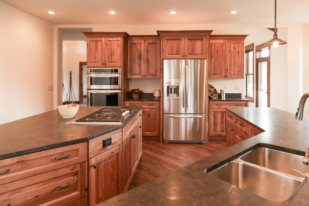Open concept kitchen - mid-sized rustic l-shaped dark wood floor and brown floor open concept kitchen idea with an undermount sink, raised-panel cabinets, medium tone wood cabinets, two islands and gray countertops