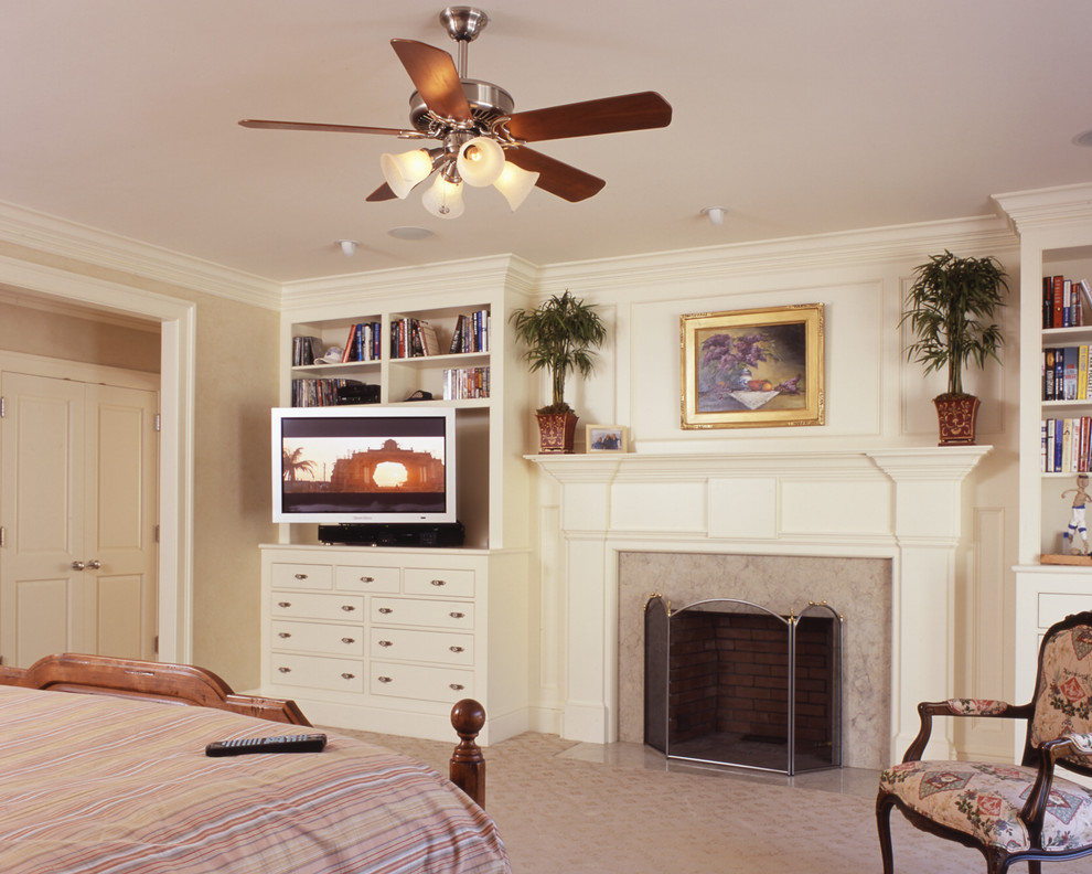 This is an example of a large traditional master bedroom in New York with beige walls, carpet, a standard fireplace and a stone fireplace surround.