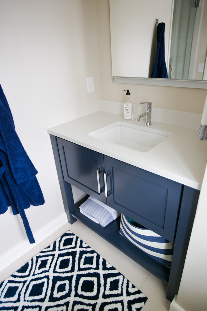 Mid-sized transitional kids bathroom in Indianapolis with ceramic floors, an undermount sink, white benchtops, recessed-panel cabinets, blue cabinets, engineered quartz benchtops, white walls and white floor.