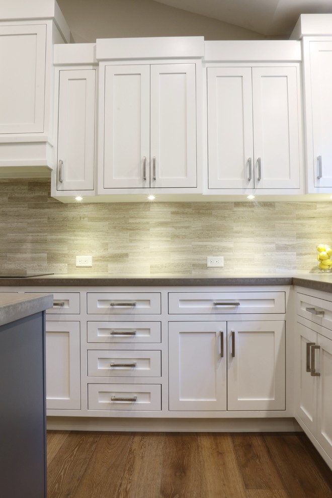 Large transitional l-shaped dark wood floor open concept kitchen photo in Grand Rapids with an undermount sink, shaker cabinets, white cabinets, quartz countertops, beige backsplash, porcelain backsplash, stainless steel appliances and an island