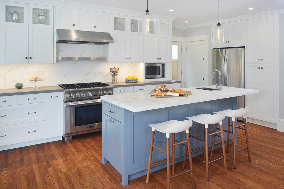 Inspiration for a mid-sized transitional l-shaped separate kitchen in San Francisco with an undermount sink, shaker cabinets, white cabinets, quartz benchtops, white splashback, porcelain splashback, stainless steel appliances, medium hardwood floors, with island and brown floor.