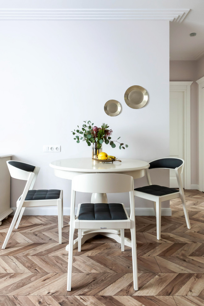 This is an example of a mid-sized transitional dining room in Moscow with pink walls, laminate floors and beige floor.