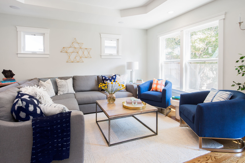 This is an example of a large transitional formal open concept living room in San Francisco with white walls, medium hardwood floors and brown floor.