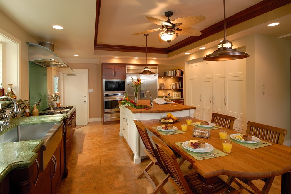 This is an example of a tropical kitchen in Hawaii with stainless steel appliances, a farmhouse sink and wood benchtops.