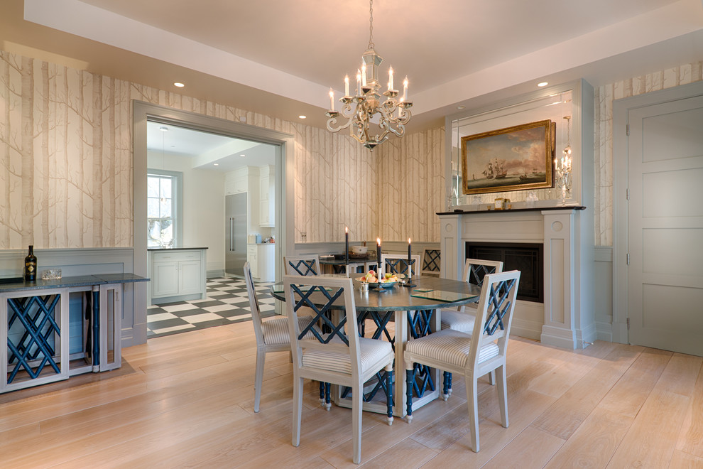 This is an example of a beach style dining room in Montreal with light hardwood floors and a standard fireplace.