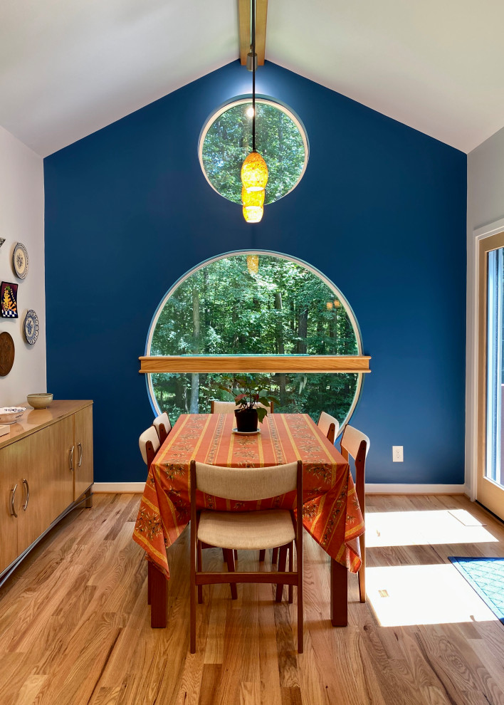 This is an example of a mid-sized contemporary kitchen/dining combo in Raleigh with blue walls, medium hardwood floors and vaulted.