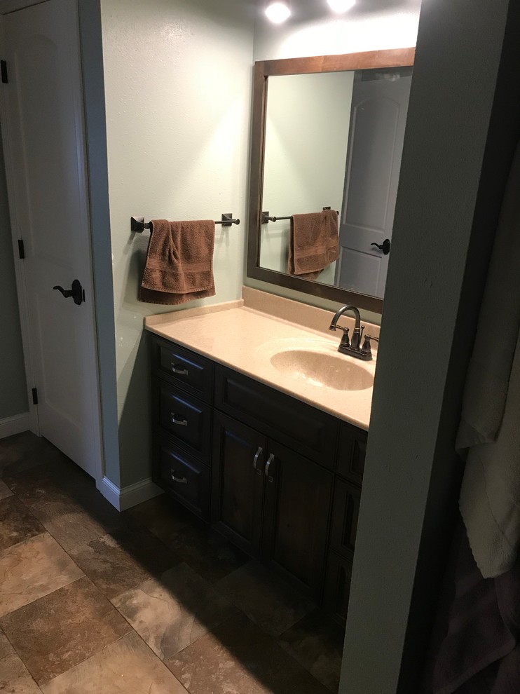 Mid-sized elegant 3/4 ceramic tile and brown floor bathroom photo with beaded inset cabinets, dark wood cabinets, gray walls and an integrated sink