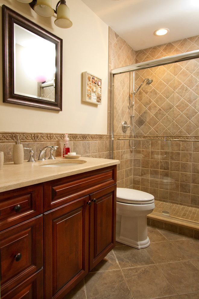 Large transitional master bathroom in Other with an undermount sink, raised-panel cabinets, dark wood cabinets, granite benchtops, a drop-in tub, a two-piece toilet, beige tile, stone tile, ceramic floors, an alcove shower, beige walls and a sliding shower screen.