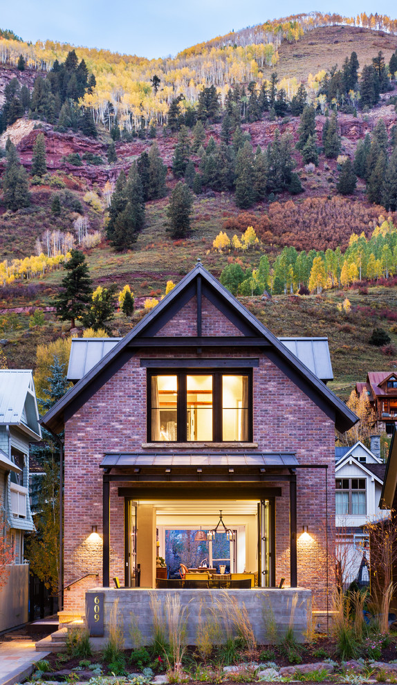This is an example of a transitional two-storey brick exterior in Denver with a gable roof.