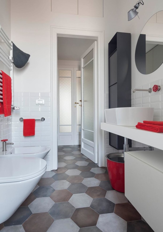 This is an example of a mid-sized contemporary 3/4 bathroom in Milan with white cabinets, white tile, subway tile, white walls, porcelain floors, a vessel sink, concrete benchtops, multi-coloured floor, white benchtops, flat-panel cabinets and a bidet.