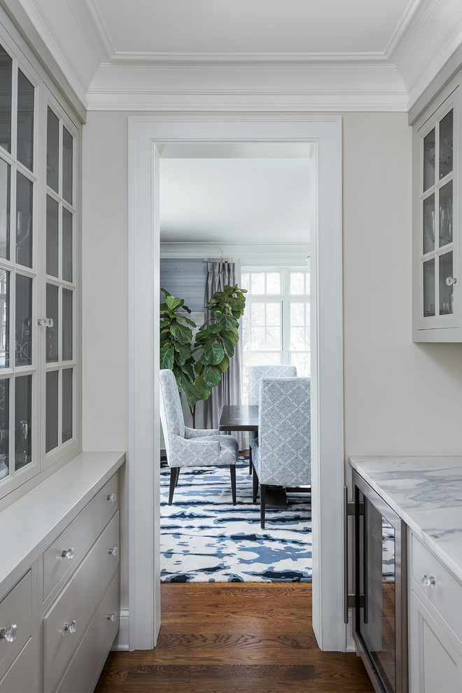 Mid-sized transitional medium tone wood floor and brown floor eat-in kitchen photo in Chicago with a farmhouse sink, beaded inset cabinets, blue cabinets, marble countertops, white backsplash, ceramic backsplash, stainless steel appliances, two islands and white countertops