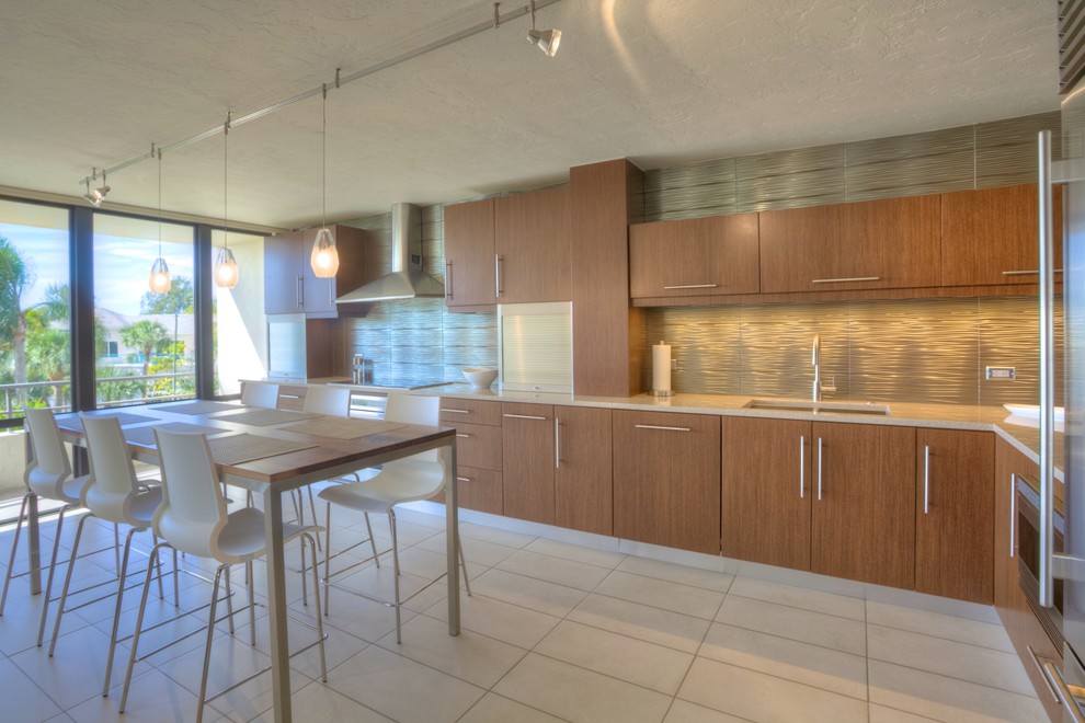 This is an example of a large contemporary l-shaped separate kitchen in Tampa with an undermount sink, flat-panel cabinets, medium wood cabinets, metal splashback, stainless steel appliances, ceramic floors, beige floor and beige benchtop.