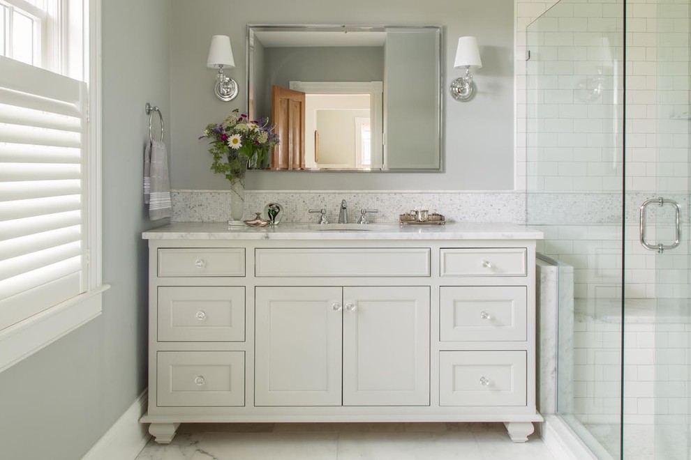 This is an example of a mid-sized transitional bathroom in Providence with furniture-like cabinets, white cabinets, an alcove shower, grey walls, marble floors, an undermount sink, quartzite benchtops, white floor, a hinged shower door and white benchtops.
