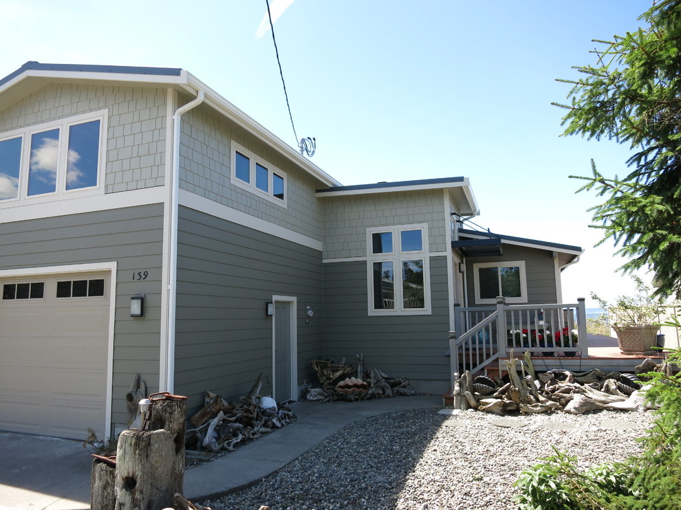 Photo of a mid-sized beach style two-storey grey house exterior in Seattle with concrete fiberboard siding, a gable roof and a shingle roof.