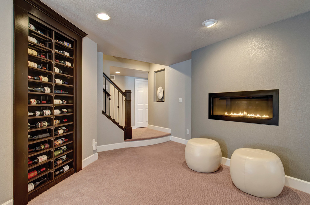 Inspiration for a small transitional wine cellar in Denver with carpet, display racks and beige floor.
