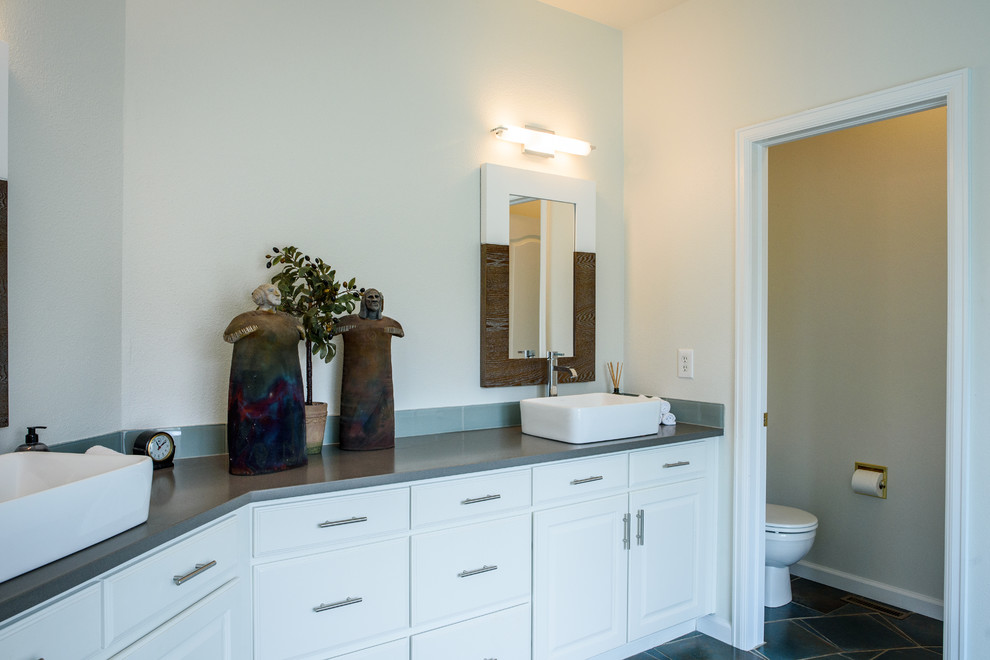 Large transitional master gray tile and glass tile concrete floor drop-in bathtub photo in Denver with shaker cabinets, white cabinets, white walls, a vessel sink and quartz countertops