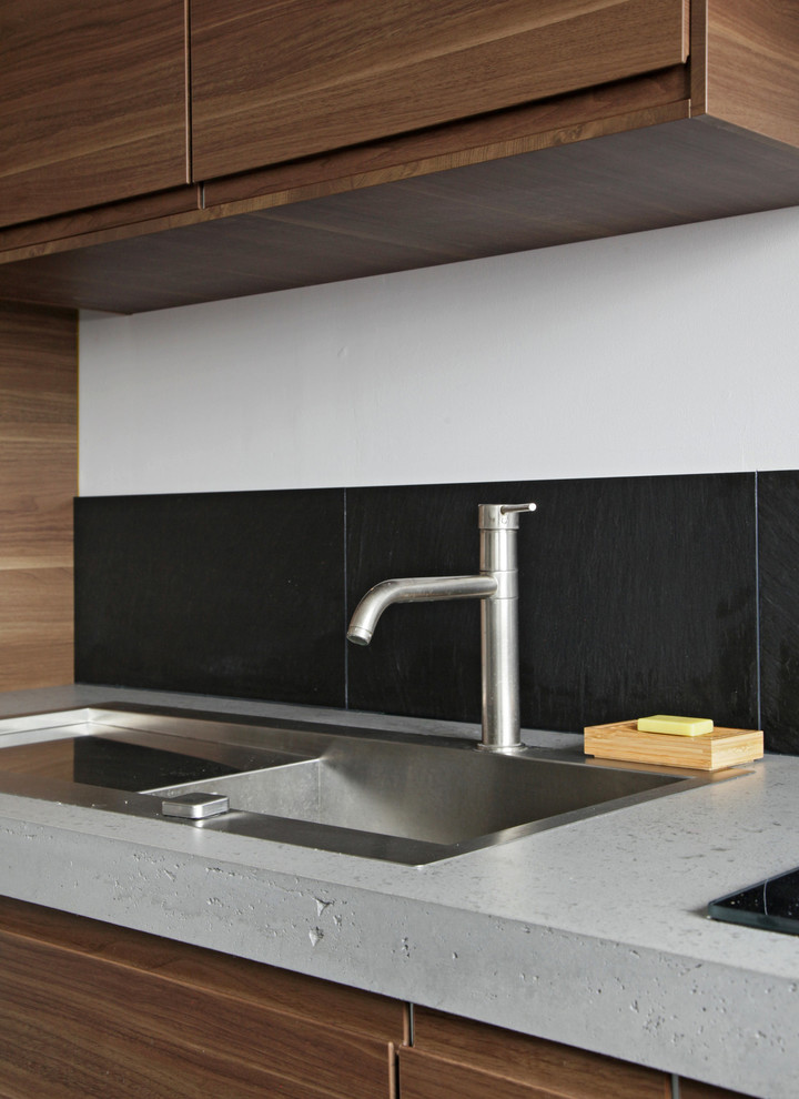 Contemporary kitchen in London with concrete benchtops.