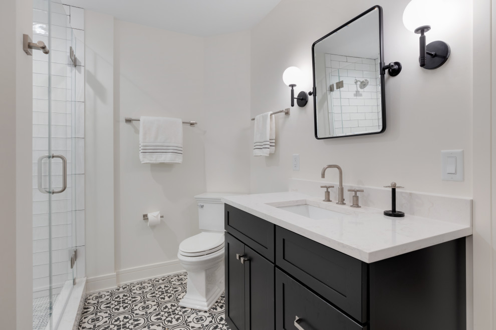 This is an example of a bathroom in Milwaukee with shaker cabinets, blue cabinets, a corner shower, a one-piece toilet, white tile, subway tile, white walls, porcelain floors, an undermount sink, engineered quartz benchtops, multi-coloured floor, a hinged shower door, white benchtops, a single vanity and a built-in vanity.