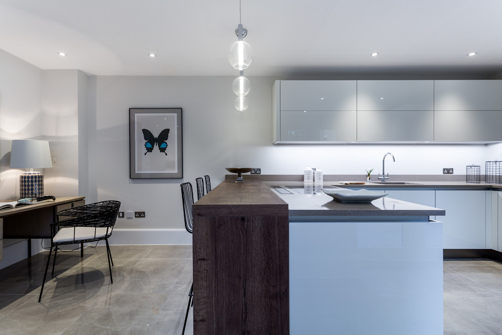 Inspiration for a mid-sized contemporary u-shaped open plan kitchen in Essex with an undermount sink, flat-panel cabinets, white cabinets, quartzite benchtops, panelled appliances, porcelain floors and a peninsula.