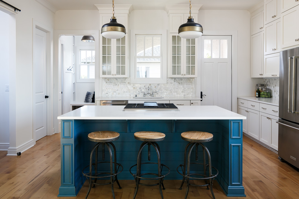 Inspiration for a mid-sized arts and crafts l-shaped eat-in kitchen in Louisville with a single-bowl sink, shaker cabinets, white cabinets, quartz benchtops, white splashback, stone tile splashback, stainless steel appliances, light hardwood floors and with island.