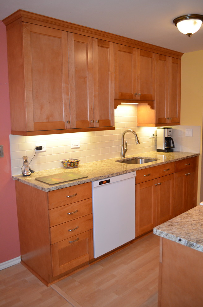 Inspiration for a small transitional galley light wood floor eat-in kitchen remodel in Seattle with an undermount sink, shaker cabinets, medium tone wood cabinets, granite countertops, white backsplash, subway tile backsplash and white appliances