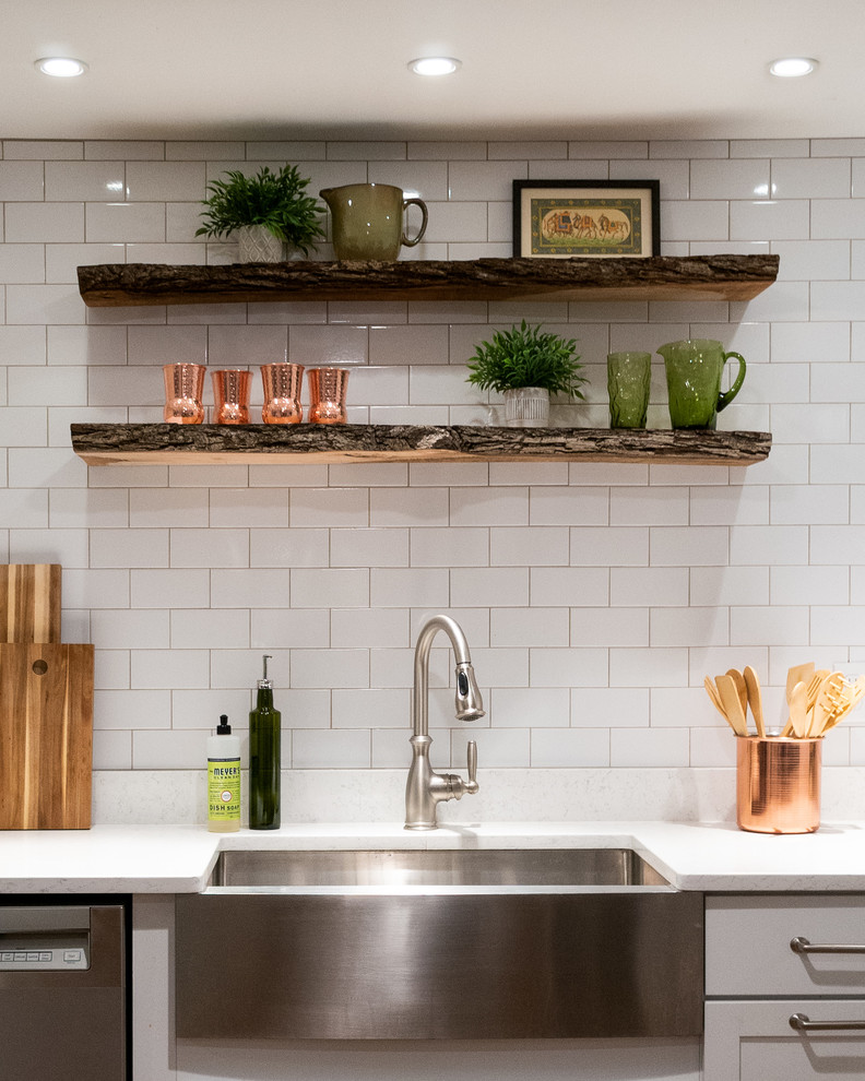 Design ideas for a small eclectic l-shaped kitchen in DC Metro with a farmhouse sink, shaker cabinets, white cabinets, quartz benchtops, white splashback, subway tile splashback, stainless steel appliances, no island, brown floor, white benchtop and vinyl floors.
