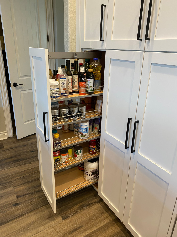 Modelo de cocina costera con armarios estilo shaker, puertas de armario blancas, suelo laminado y suelo multicolor