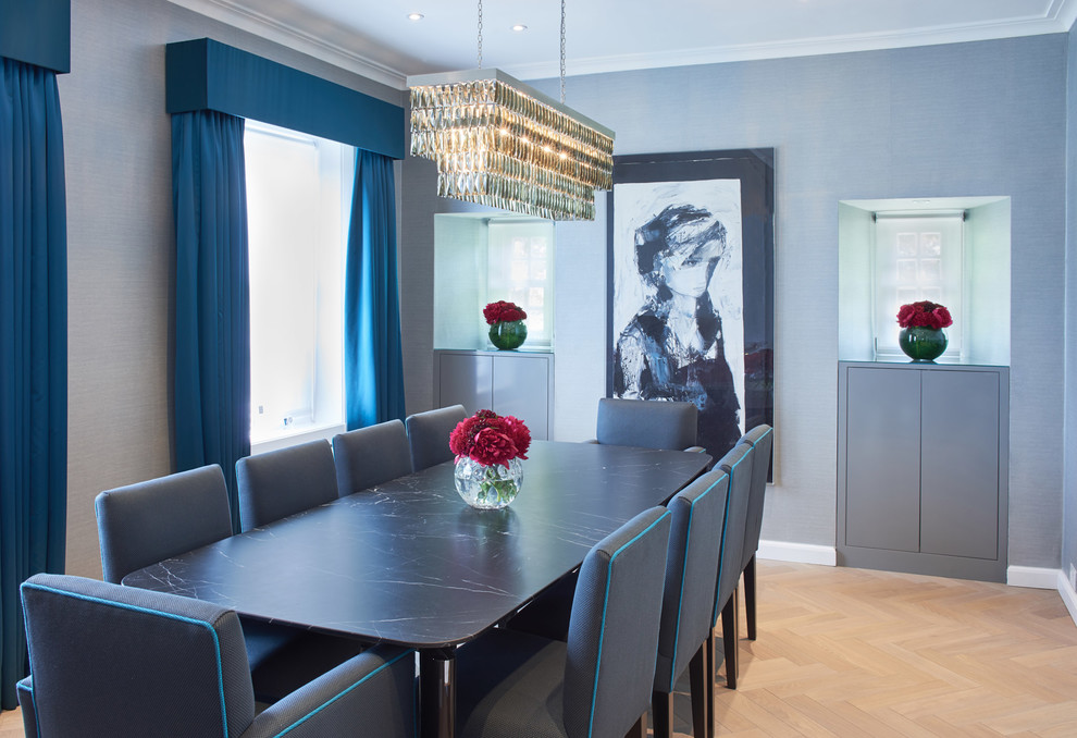 Inspiration for a transitional separate dining room in London with grey walls and light hardwood floors.