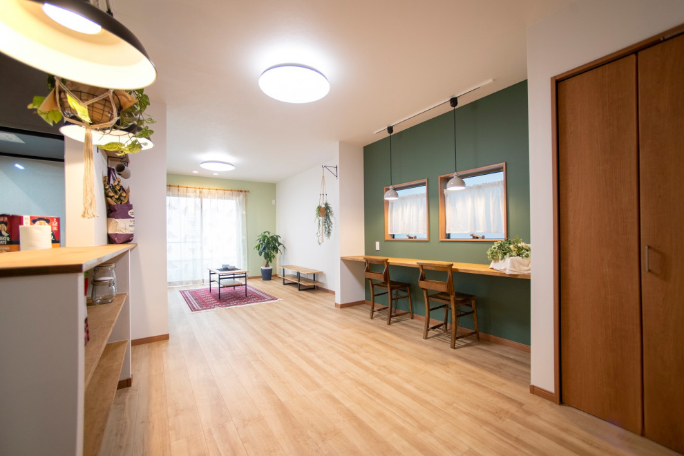 На фото: маленькая гостиная-столовая в стиле ретро с зелеными стенами и полом из фанеры для на участке и в саду с