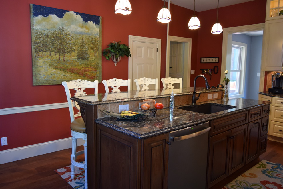 Transitional medium tone wood floor kitchen photo with an undermount sink, raised-panel cabinets, white cabinets, quartz countertops, beige backsplash, ceramic backsplash, stainless steel appliances and an island