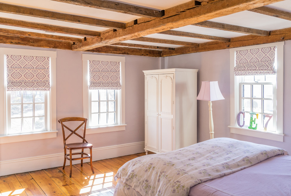 Mid-sized country guest bedroom in Boston with purple walls and light hardwood floors.
