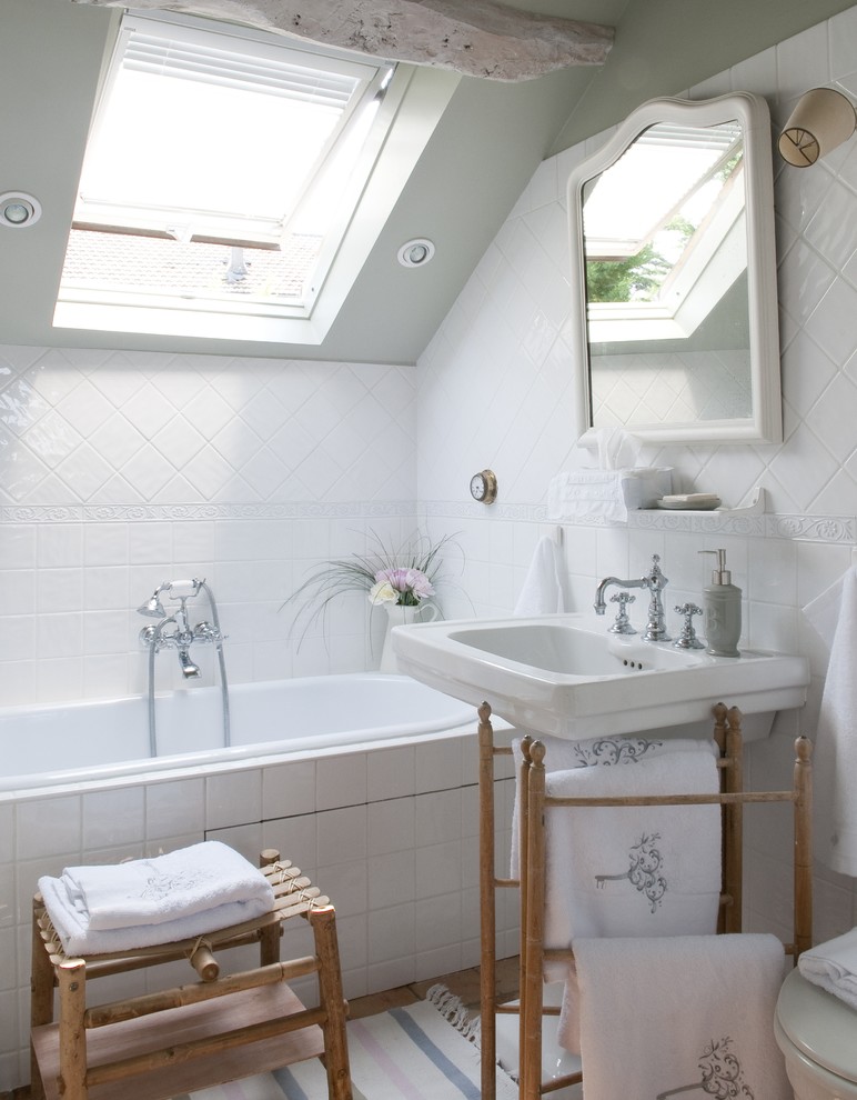 Inspiration for a traditional bathroom in Paris with a pedestal sink, a drop-in tub and grey walls.