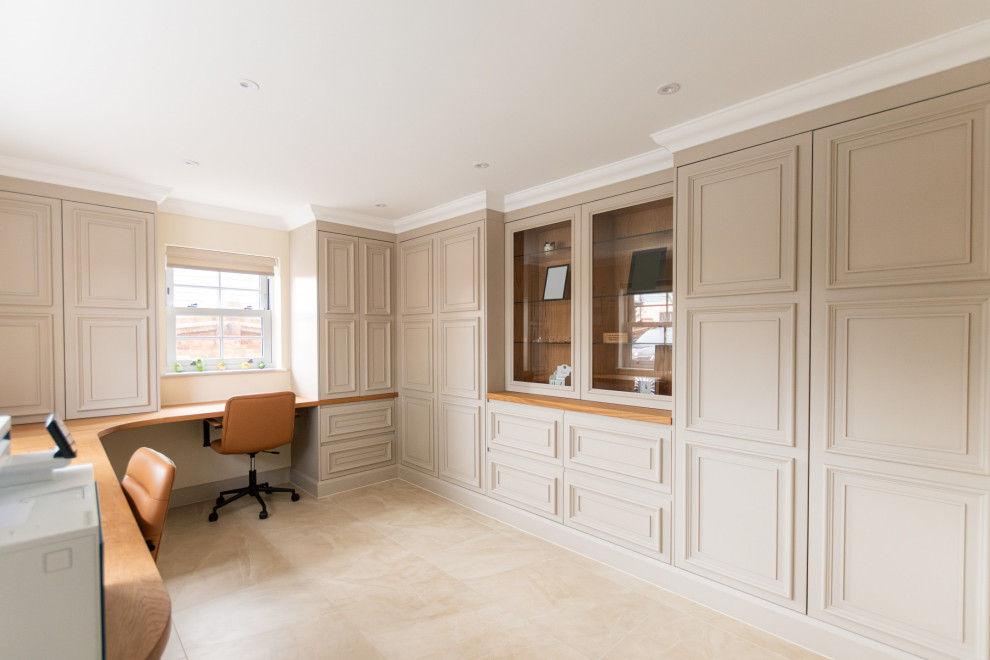 Photo of a large contemporary study in Essex with beige walls, limestone flooring, a built-in desk and beige floors.