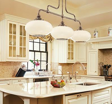 This is an example of a mid-sized traditional u-shaped eat-in kitchen in Salt Lake City with a drop-in sink, raised-panel cabinets, white cabinets, quartz benchtops, beige splashback, stone tile splashback, stainless steel appliances and with island.