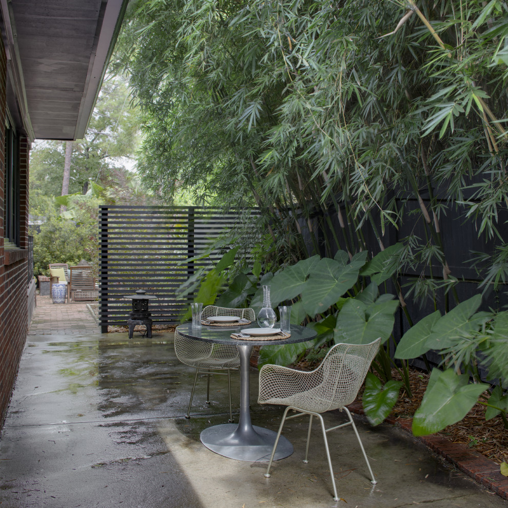 На фото: маленький двор на внутреннем дворе в современном стиле с покрытием из бетонных плит без защиты от солнца для на участке и в саду с