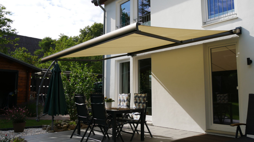 Example of a small tuscan backyard patio design in Charleston with an awning